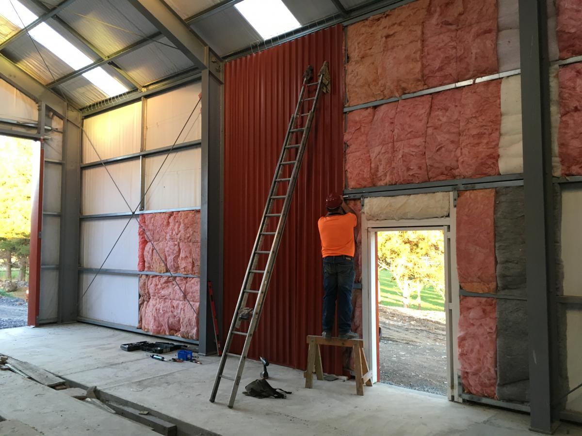 More cladding fitted to internal wall in workshop 