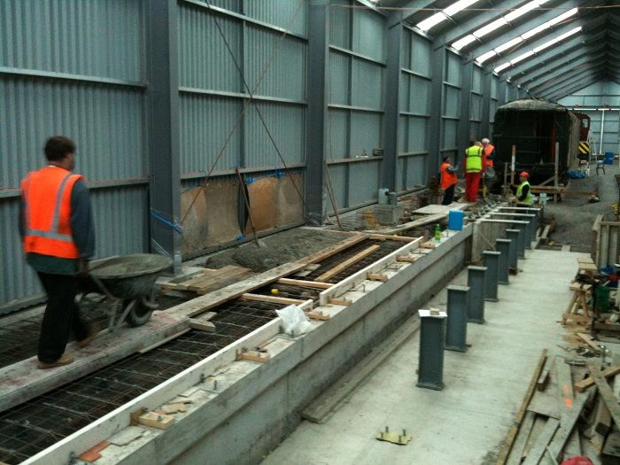 Ray wheeling through another load of concrete to the floor area and pit wall.